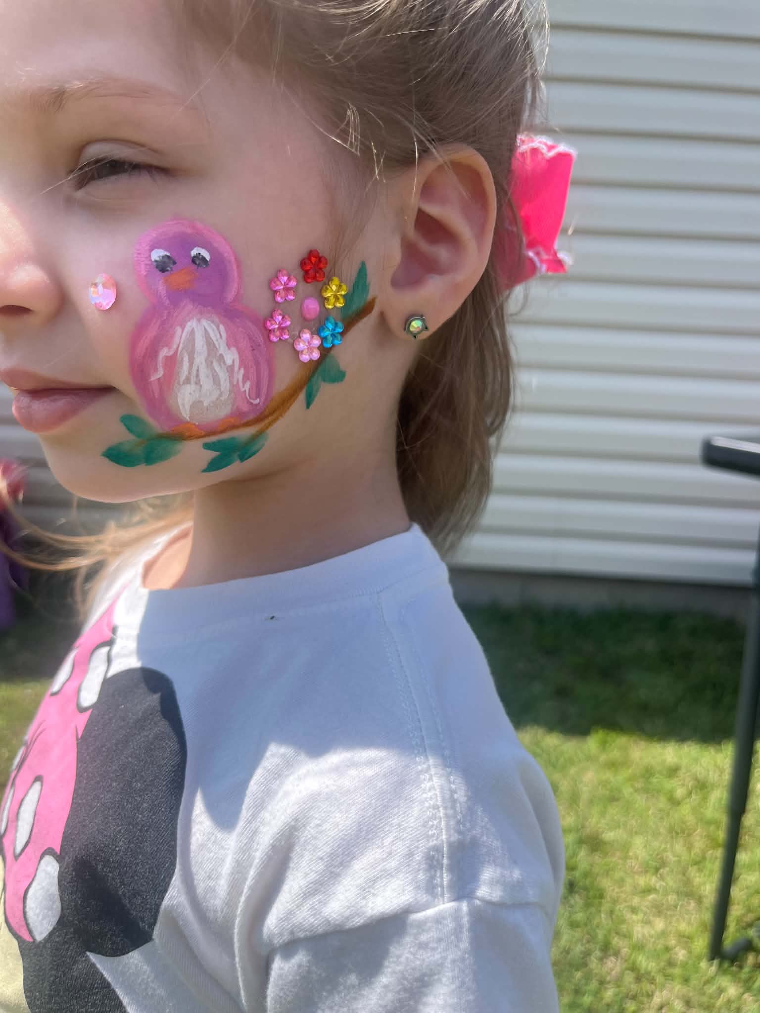 Bird face painting with jeweled flowers